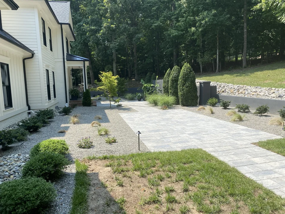 Paver courtyard beside a home with planted borders