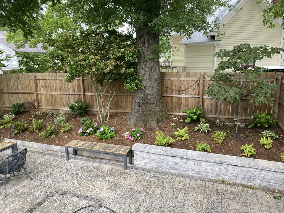 Stone seat walls bordering a planted backyard garden