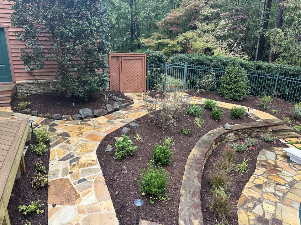 Curving stone paths around a mulched garden bed with shrubs