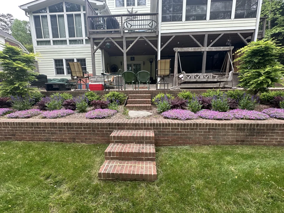 Brick garden steps between terraced beds of colorful flowering plants